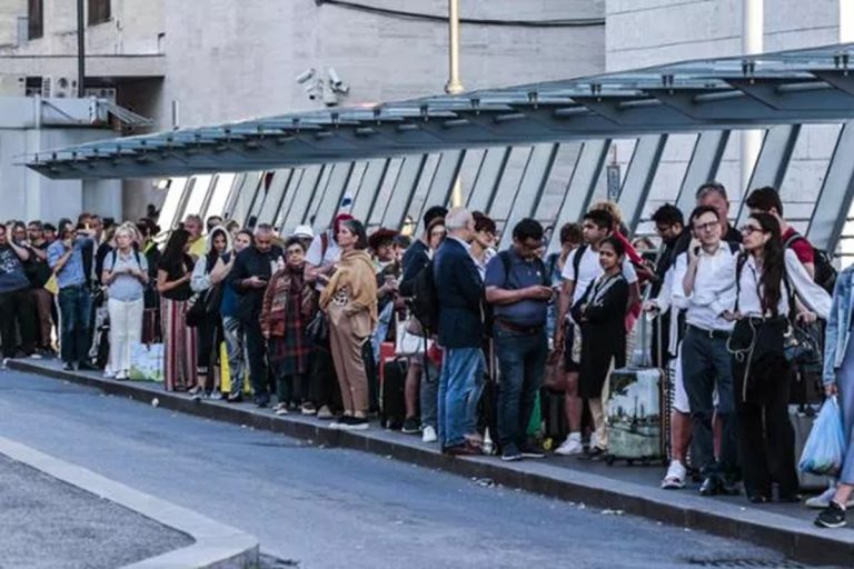 Lunghe file in attesa per i taxi in una stazione italiana
